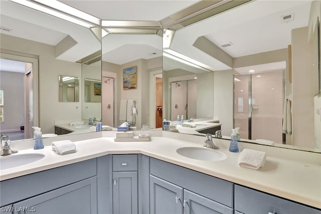 bathroom with an enclosed shower and dual vanity