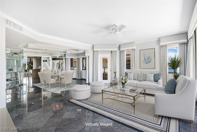 living room featuring crown molding and ceiling fan with notable chandelier