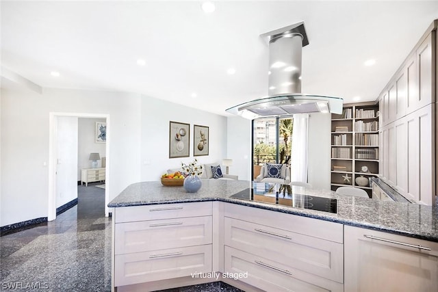 kitchen with island exhaust hood, black electric cooktop, dark stone counters, and white cabinetry