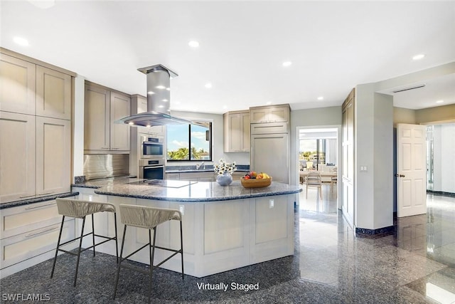 kitchen with island exhaust hood, built in refrigerator, double oven, and a wealth of natural light