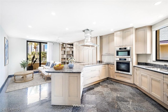 kitchen featuring sink, island range hood, a wealth of natural light, and a kitchen bar