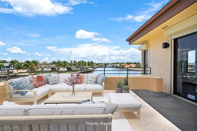 view of patio featuring a balcony, a water view, and an outdoor living space