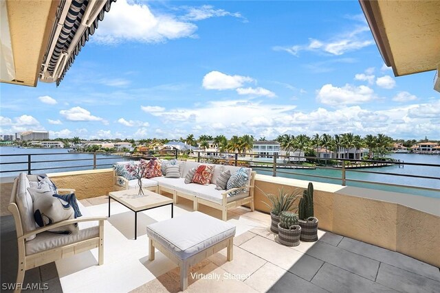 view of patio / terrace with a balcony, a water view, and an outdoor living space