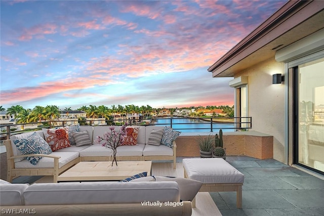 patio terrace at dusk featuring a balcony and an outdoor hangout area