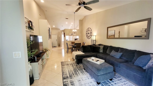 tiled living room featuring vaulted ceiling and ceiling fan with notable chandelier