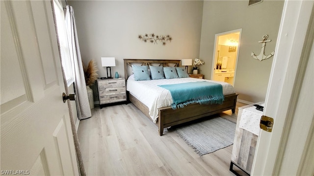 bedroom featuring light hardwood / wood-style flooring and ensuite bath