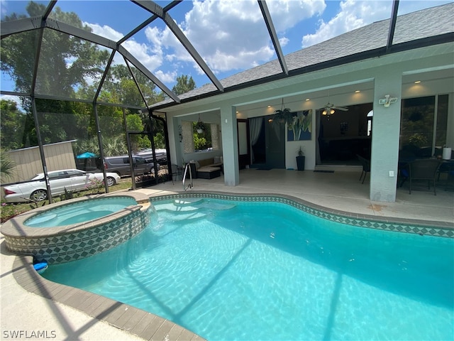 view of pool with a lanai, an in ground hot tub, ceiling fan, and a patio area