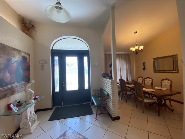 tiled foyer entrance featuring a notable chandelier