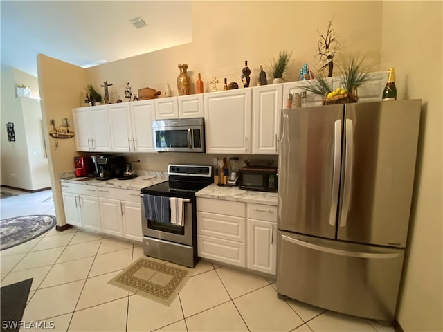 kitchen featuring white cabinetry, stainless steel appliances, and light tile floors