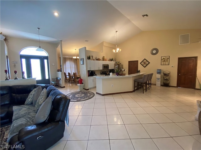 living room with high vaulted ceiling, light tile floors, and a chandelier