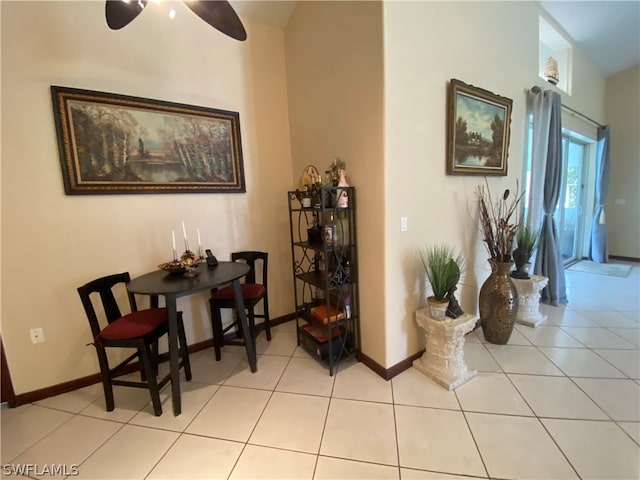 living area with ceiling fan, light tile floors, and lofted ceiling