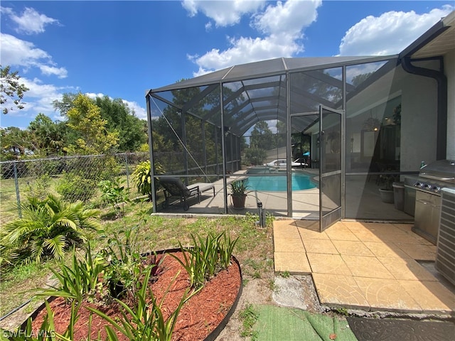 view of pool featuring area for grilling, glass enclosure, and a patio