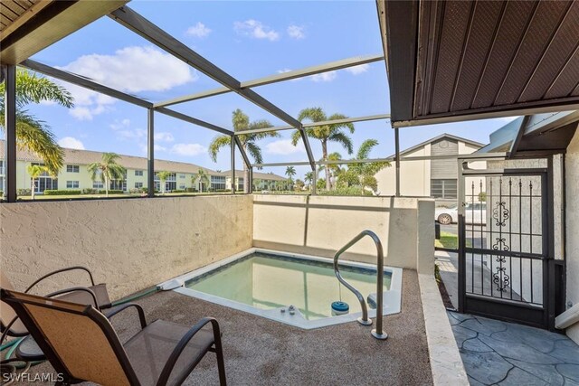 view of pool with a jacuzzi and glass enclosure