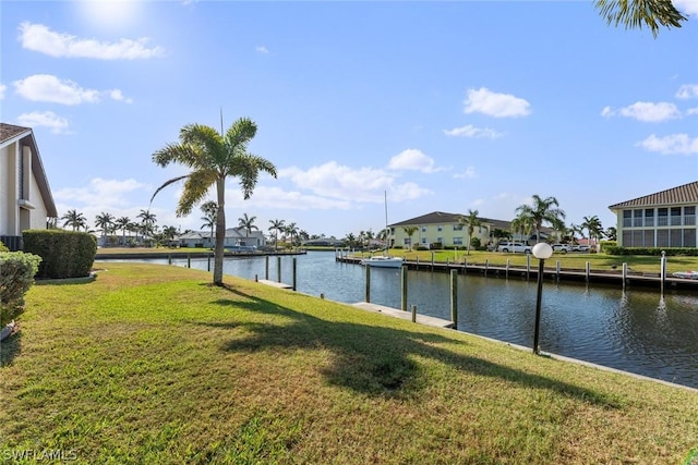 dock area with a yard and a water view