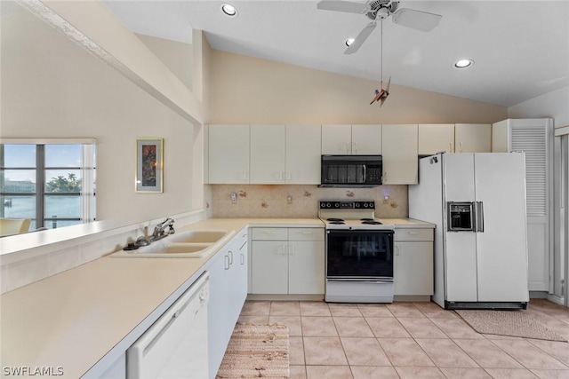 kitchen with sink, light tile patterned flooring, lofted ceiling, white appliances, and white cabinets