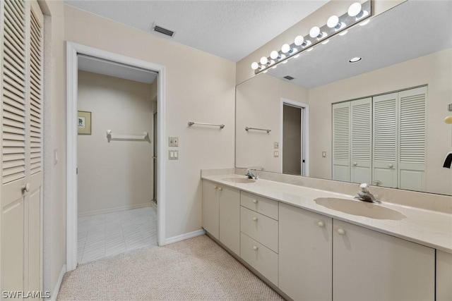 bathroom featuring tile patterned flooring, a textured ceiling, and vanity