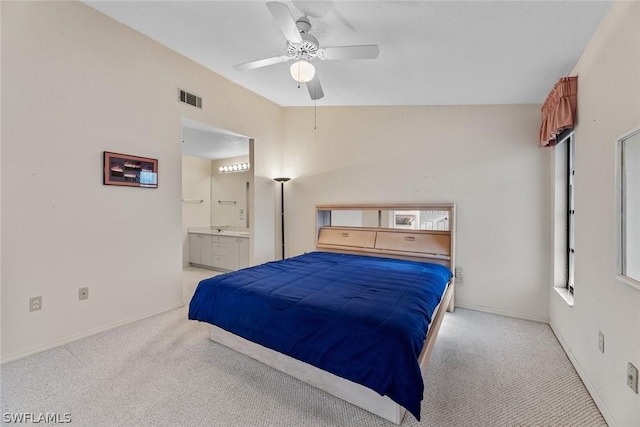 carpeted bedroom featuring ceiling fan, ensuite bathroom, and vaulted ceiling