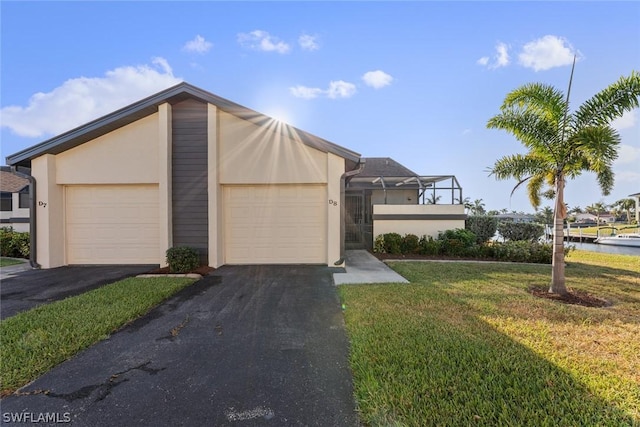 view of front of house featuring a water view, a garage, and a front lawn