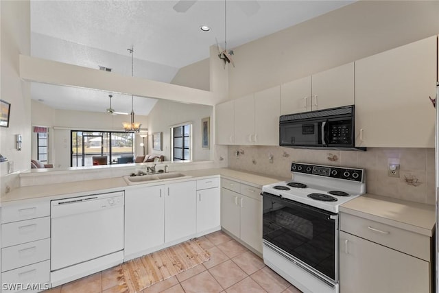 kitchen featuring white cabinets, white appliances, vaulted ceiling, and sink