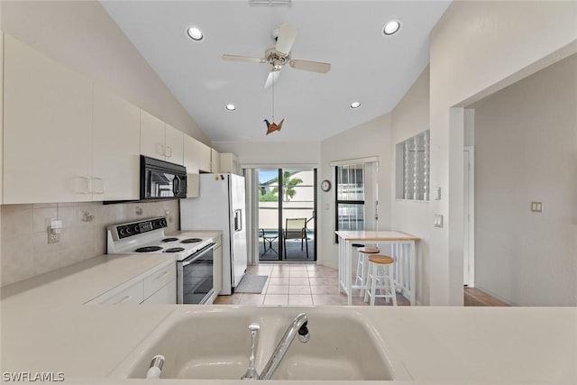 kitchen featuring lofted ceiling, white cabinets, white appliances, and ceiling fan