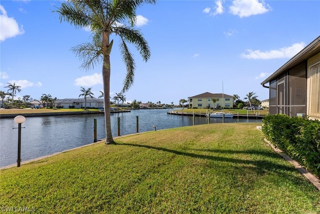 view of yard with a water view and a dock