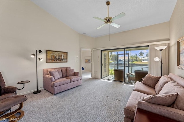 living room with ceiling fan, a water view, light carpet, and high vaulted ceiling