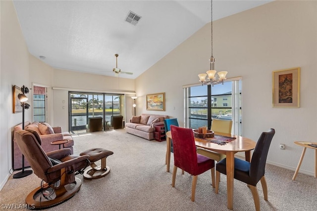 carpeted dining area featuring high vaulted ceiling, a water view, ceiling fan with notable chandelier, and a wealth of natural light