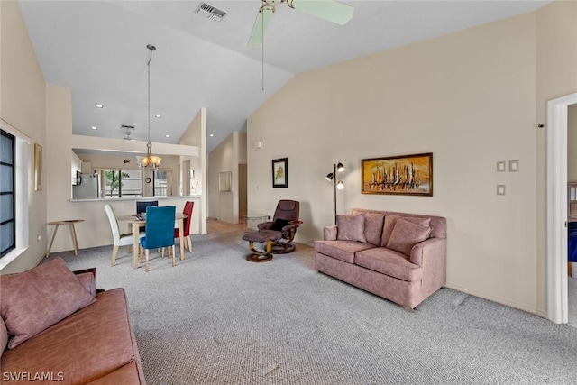 living room with high vaulted ceiling, light colored carpet, and ceiling fan with notable chandelier