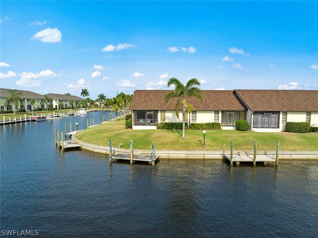 view of dock with a yard and a water view