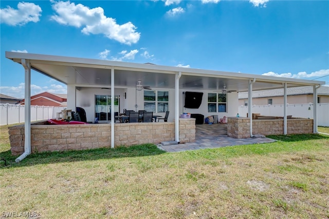 rear view of house with a patio area, ceiling fan, and a lawn