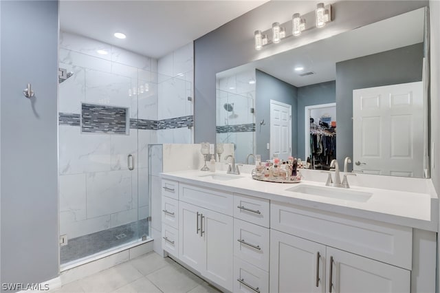 bathroom with tile flooring, walk in shower, large vanity, and dual sinks