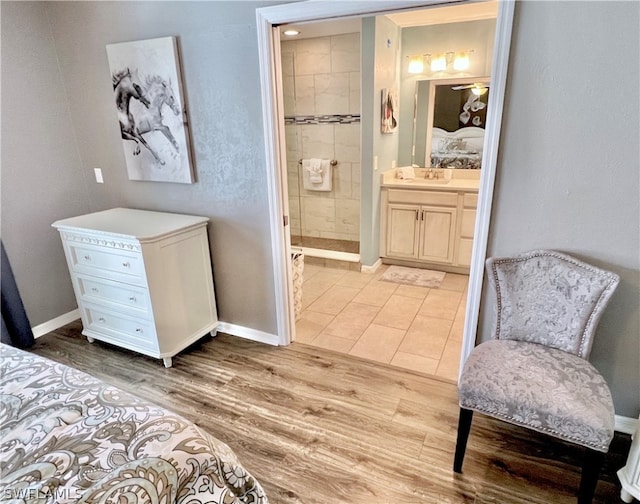 bedroom featuring connected bathroom, tile flooring, and sink