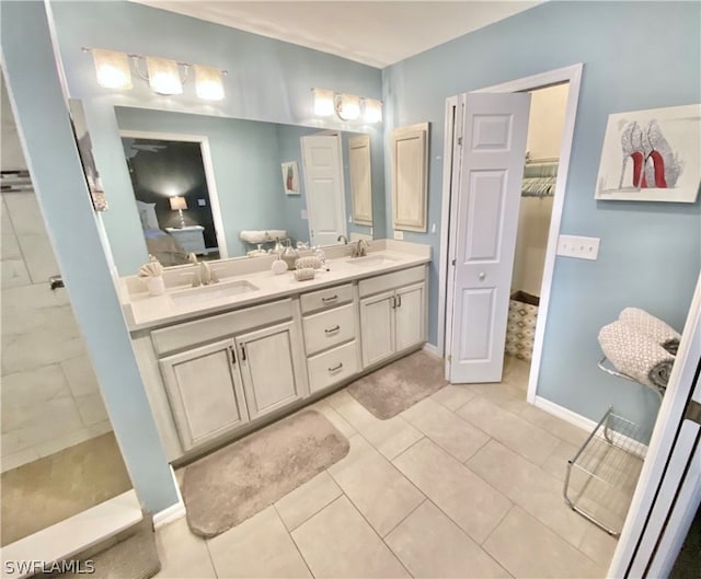 bathroom with tile flooring, dual sinks, and vanity with extensive cabinet space