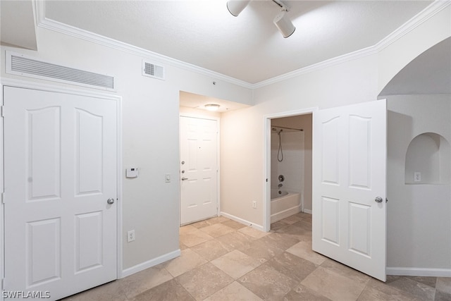 interior space featuring ornamental molding, track lighting, and light tile floors