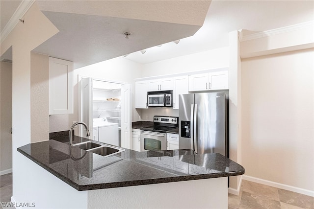 kitchen with white cabinets, sink, independent washer and dryer, stainless steel appliances, and kitchen peninsula