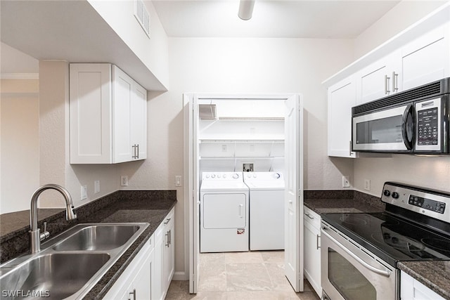 kitchen featuring appliances with stainless steel finishes, light tile floors, sink, white cabinetry, and dark stone countertops