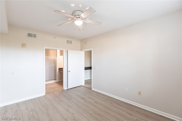 unfurnished bedroom featuring a walk in closet, light hardwood / wood-style flooring, ceiling fan, and a closet