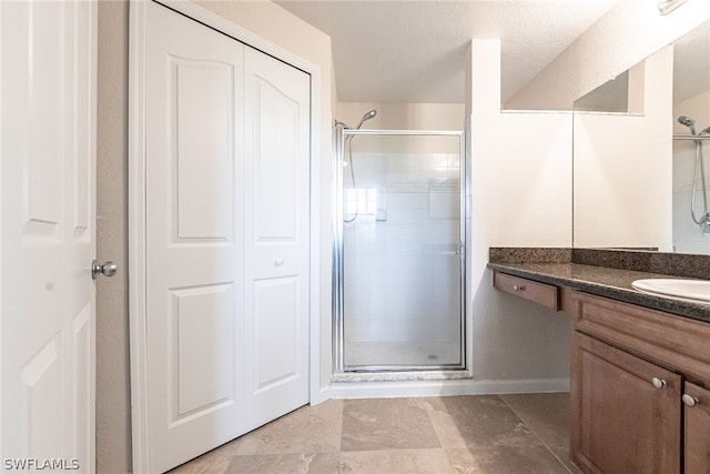 bathroom with walk in shower, vanity, and tile flooring