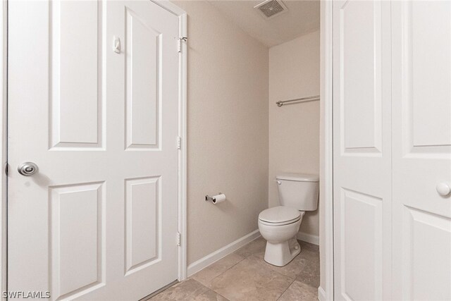 bathroom featuring toilet and tile floors