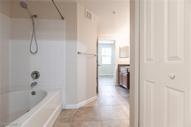 bathroom with tiled shower / bath combo, vanity, and tile flooring