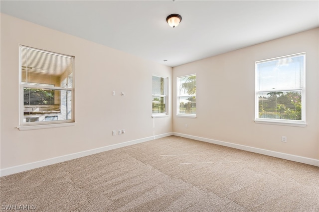 unfurnished room featuring light carpet