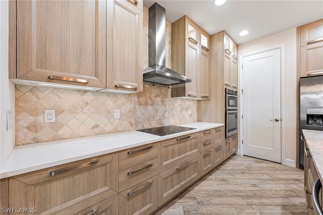 kitchen featuring wall chimney exhaust hood, light hardwood / wood-style flooring, stainless steel appliances, and backsplash