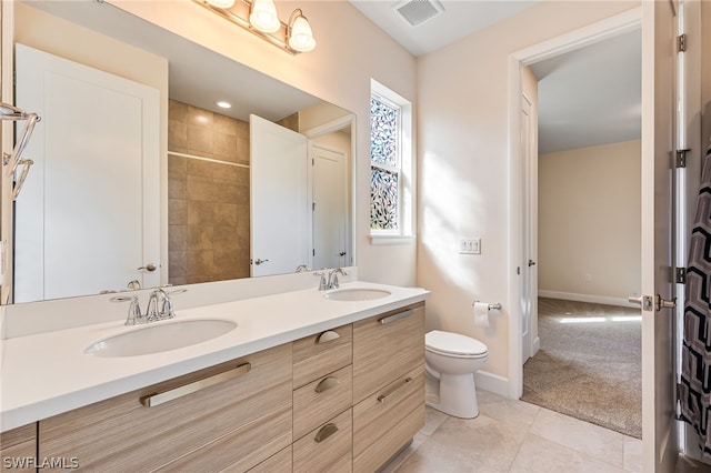 bathroom featuring dual sinks, toilet, tile floors, and vanity with extensive cabinet space