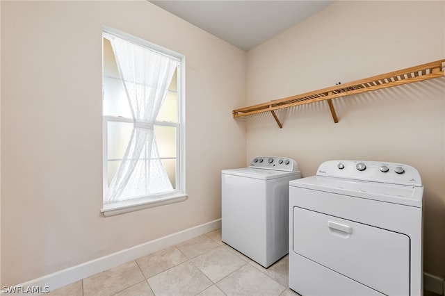 laundry area with light tile floors and washing machine and clothes dryer