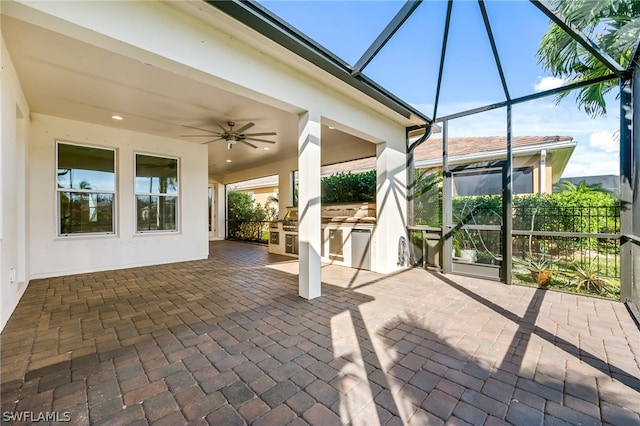 view of patio with exterior kitchen, glass enclosure, and ceiling fan