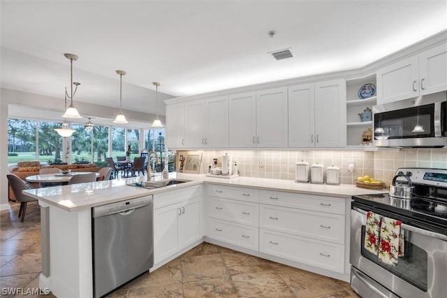 kitchen with white cabinets, decorative light fixtures, and appliances with stainless steel finishes