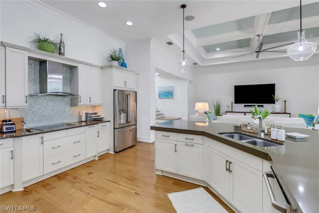 kitchen featuring light wood-type flooring, high end fridge, wall chimney exhaust hood, coffered ceiling, and decorative light fixtures