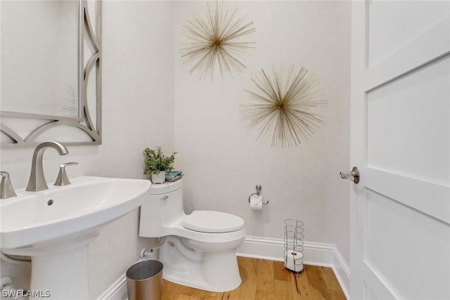 bathroom with sink, hardwood / wood-style floors, and toilet