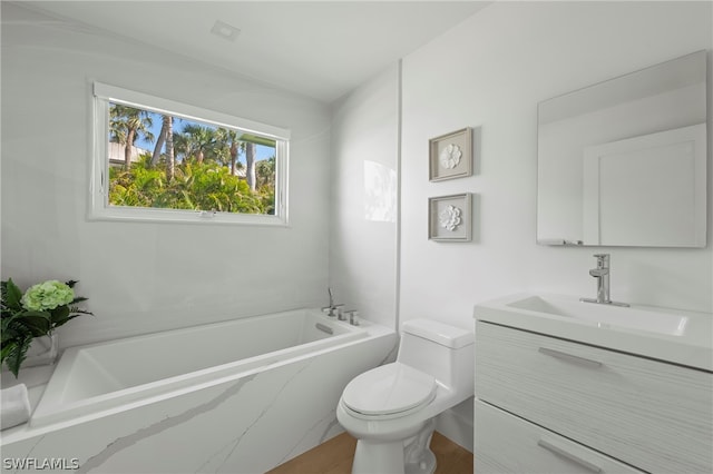 bathroom with vanity, toilet, and tiled tub