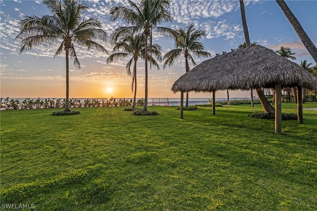 surrounding community with a water view, a gazebo, and a lawn